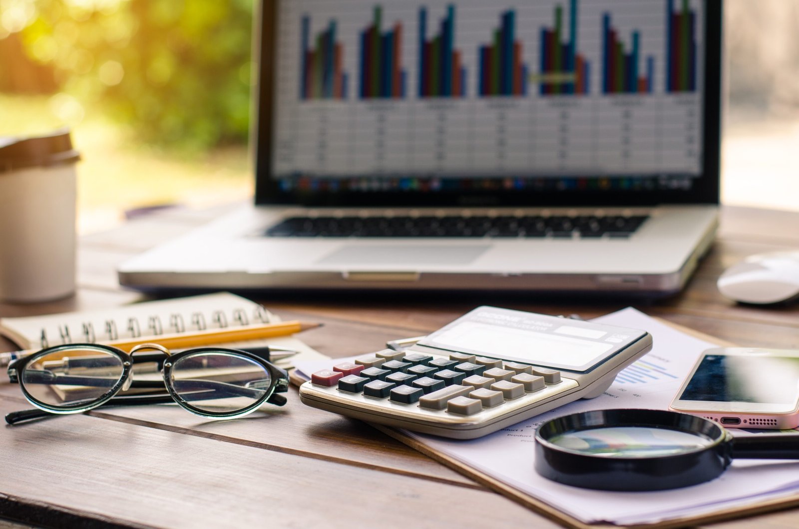 Calculator, laptop, and financial reports on a desk