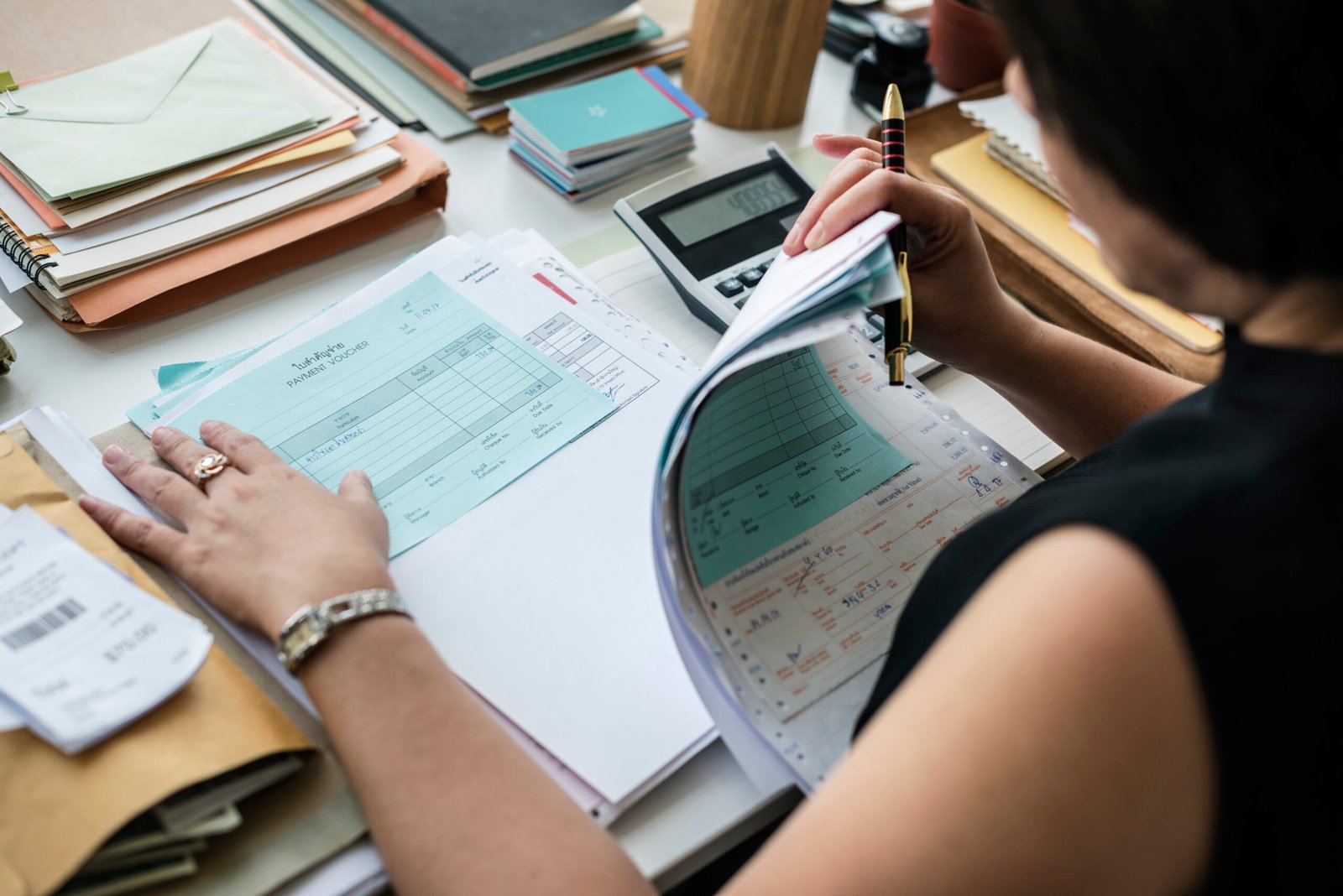 Woman reviewing financial paperwork beside a calculator
